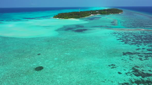 Wide flying travel shot of a white sandy paradise beach and aqua turquoise water background in vibra