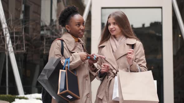 Beautiful Girls Holding Shopping Bags Going Out of the Mall