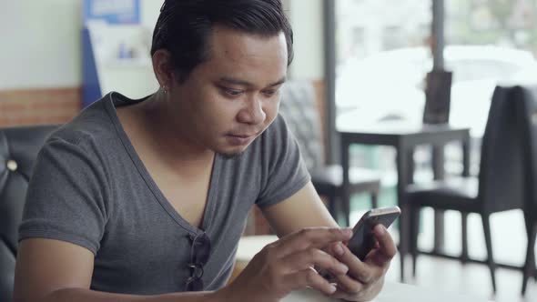 man using smartphone in cafe