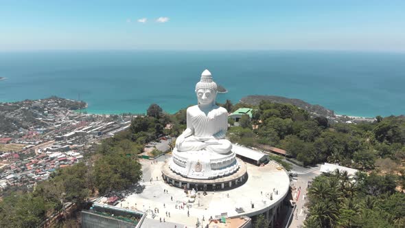 Parallax view of The Great Buddha of Phuket against the blue ocean landscape 