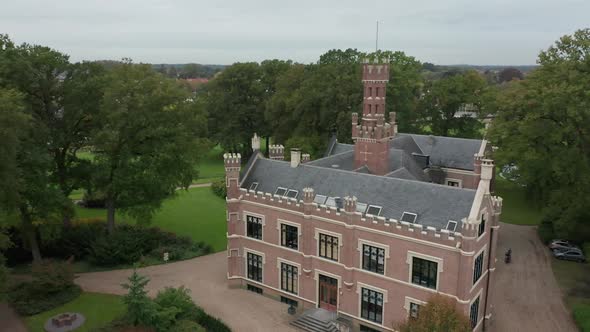 Close Aerial view of a beautiful old mansion on a lush, green estate