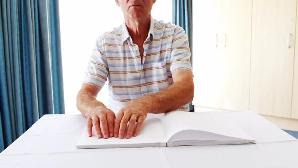 Senior man reading a braille book