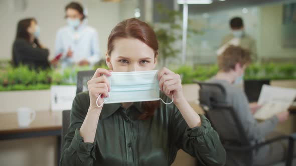 A Beautiful Lady is Putting a Protective Mask on Her Face