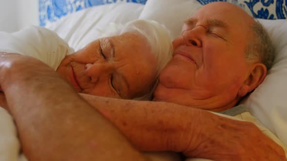 Close-up of Caucasian senior couple sleeping on bed in bedroom at comfortable home 4k