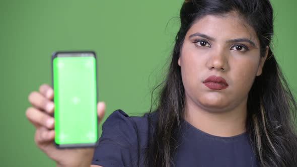 Young Overweight Beautiful Indian Businesswoman Against Green Background