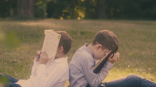 Boys with Dark Hair Wearing Shirts Hold Textbooks on Face