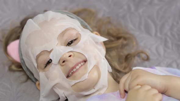 Teen Girl Applying Moisturizing Face Mask. Child Kid Take Care of Skin with Cosmetic Facial Mask