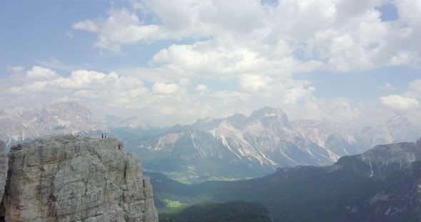 Aerial drone view of a man and woman couple mountain climbing on top of a tower