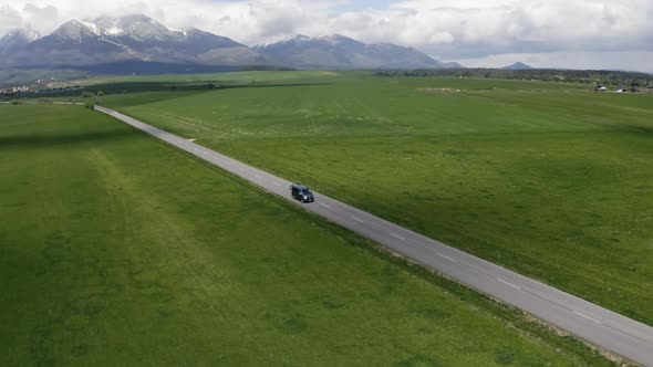 Drone Shot Around the Caravan Caravan on the Road in the Background of Mountains