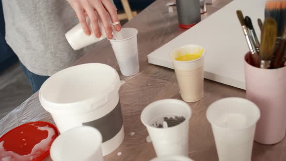 Hands of Female Painter Mixing Colors