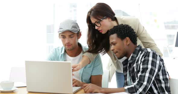 Employees Working Together on Laptop at Desk