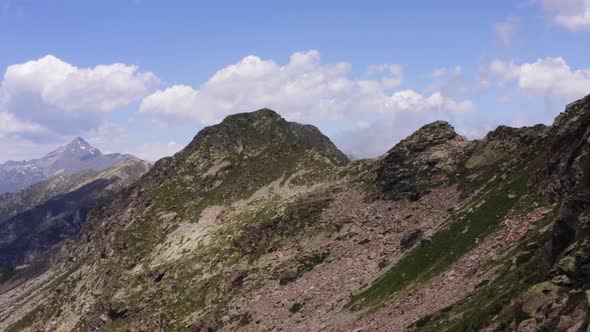 Aerial View of Edge of Mountain View with Clouds Blue Sky Desolate Landscape No Human Hard Life