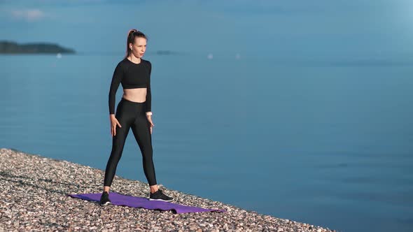 Fitness Girl Enjoying Training on Beach Making Squat at Natural Seascape