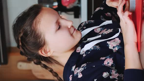 Cheerful Young Girl Filling Baking Dish with Pastry Dough