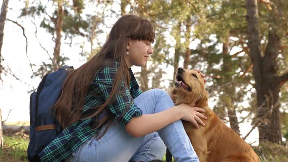 Tourist Girl in the Forest on a Halt with a Dog. Beautiful Girl Travels with a Pet. Happy Woman