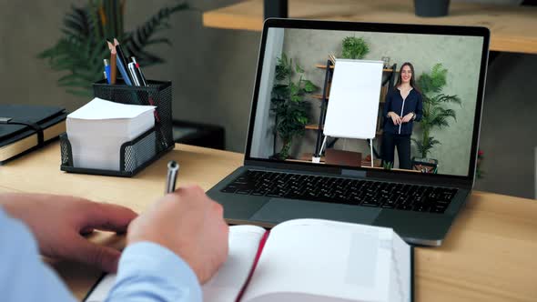 Man in Office Study Online Video Call Laptop Writes in Notebook Listen Teacher