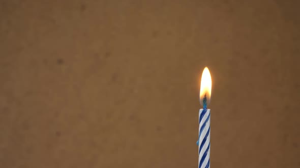 Candle Fire on Birthday Cake Celebration on Brown Background