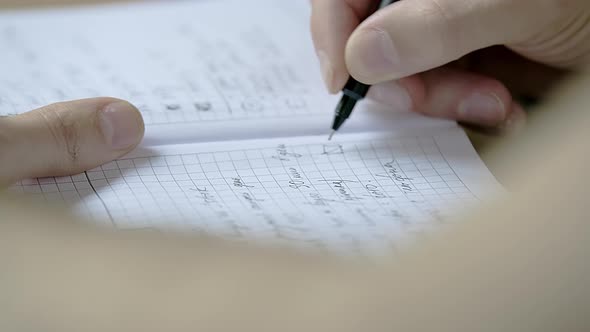 Caucasian Male is Making Notes in a Dairy