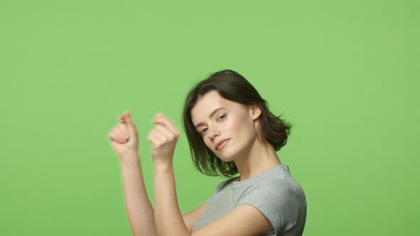Slowmotion Groovie and Joyful Carefree Happy Woman Shorthaired Girl on Green Background Lifting
