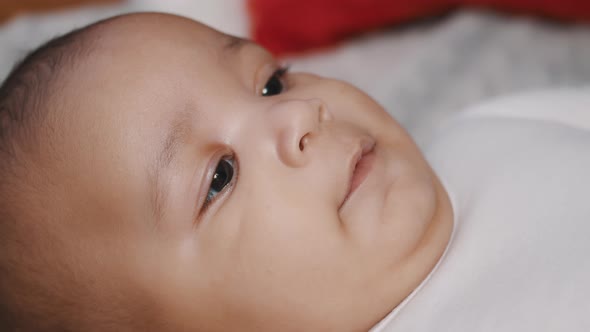 Cute Dark Skin Baby Lying on the Towel and Laughing