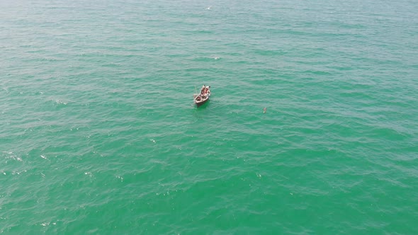 Wooden Boat Floating In Turquoise Ocean Waters Off Balochistan. Aerial Tracking Shot