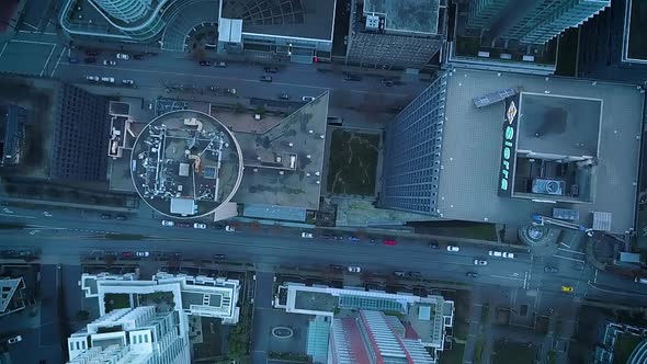 Drone circling over buildings and busy streets in a large city.