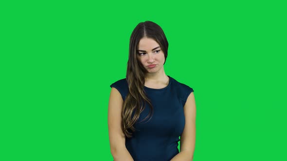 Shy sad girl in front of a green screen