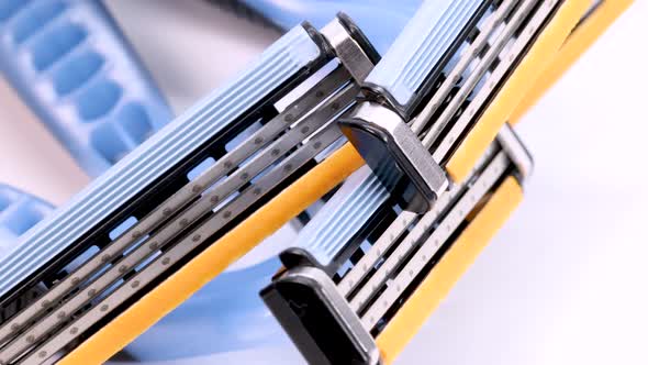 Used disposable shaver razor blades rotating on white background, macro shot in 4k.