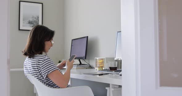 Busy businesswoman taping and texting on her smartphone