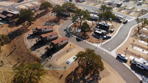 Aerial pan around of 3 cottages at an RV Park.