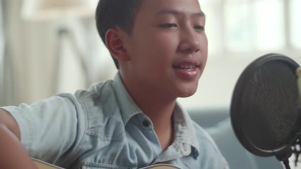 Asian Boy Playing Guitar And Sing A Song