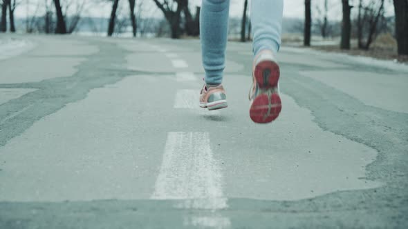 Female Feet Jogging on Road in Winter