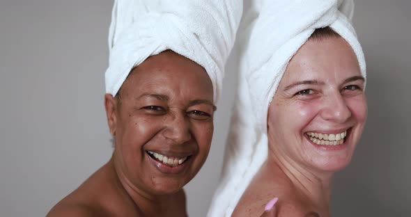 Mature caucasian and african women having fun doing beauty day together
