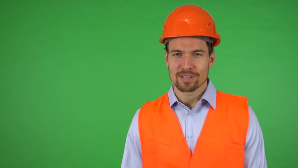 A Young Construction Worker Talks To the Camera About the Construction Around Him - Green Screen