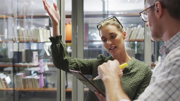 Video of happy caucasian female and male designers brainstorming in office