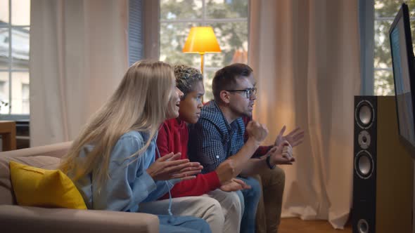 Multiracial Friends Watching Sports on TV and Screaming with Joy When Team Scores