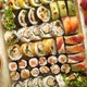 Top View Background with Set of Colorful Different Kinds of Sushi Rolls Placed on Wooden Board - VideoHive Item for Sale