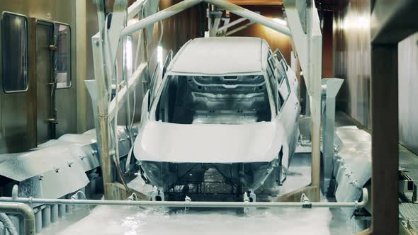 Car Being Dipped Into a Solution at a Car Factory