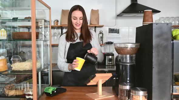 A Waitress in Apron Prepearing Coffee