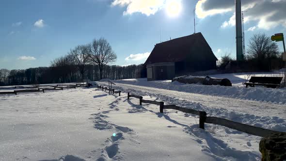 Winter Landscape With Bare Trees, House And Windmill During Daytime - tilt up shot