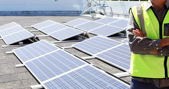 Male worker standing with arms crossed at solar station 4k