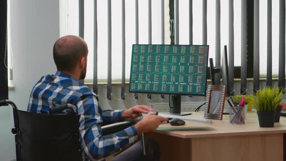 Disabled Businessman Taking Notes in Business Office