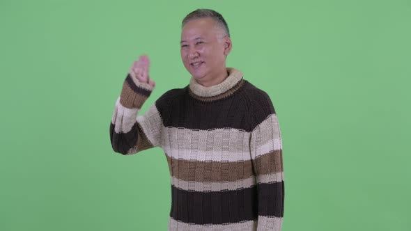 Happy Mature Japanese Man Waving Hand Ready for Winter