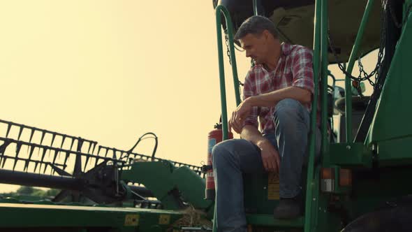 Farmer Resting Combine Machine at Countryside