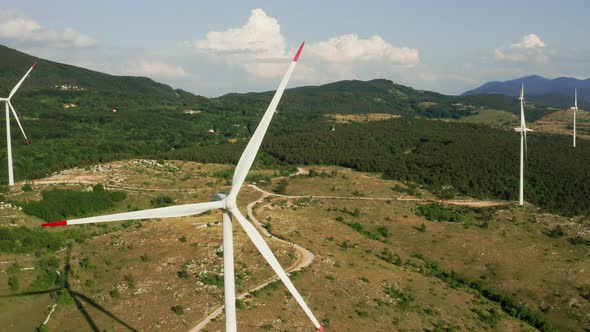 Camera Turns Around of a Spinning Wind Turbine in the Mountains