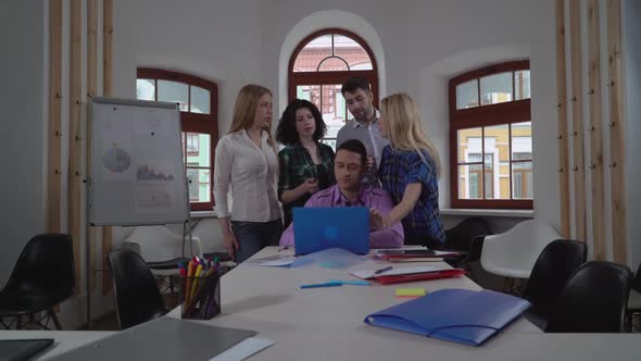 Coworkers Standing Around Boss in the Office