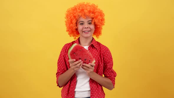 Happy Child in Fancy Orange Hair Wig Eat Water Melon Slice on Yellow Background Watermelon
