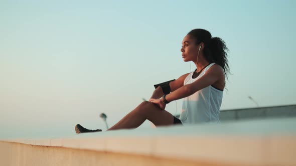 A cropped view of an african american woman doing stretching her legs