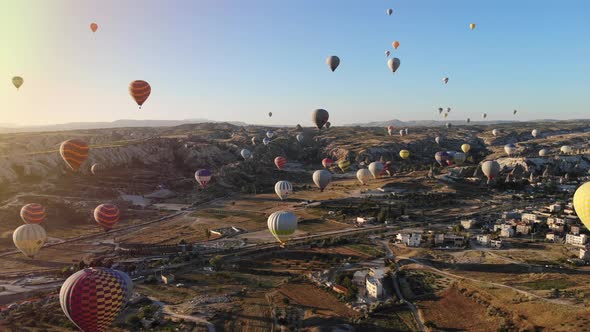 Aerial Hot Air Balloons Flying Over Hoodoos Fairy Chimneys in Cappadocia Turkey at Sunset