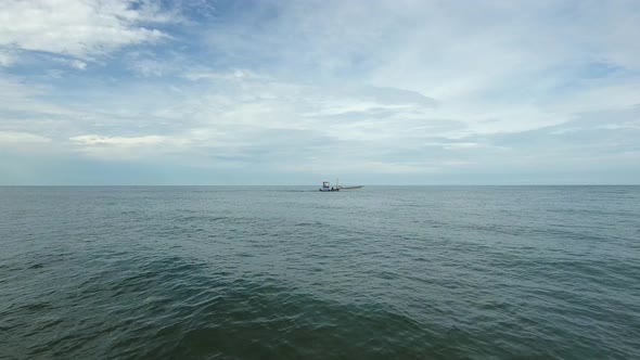 Aerial view of small fishing boat navigating on calm water, Ko Chang, Thailand.